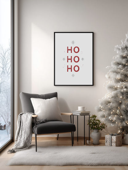 Framed 'HO HO HO' print above a chair in a living room with a Christmas tree.