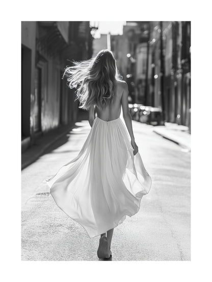 Black and white poster of a woman in a dress walking through a city street