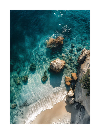 Overhead photo of a beach with turquoise water, rocks, and gentle waves. Ideal for wall art in your home, office, or studio.