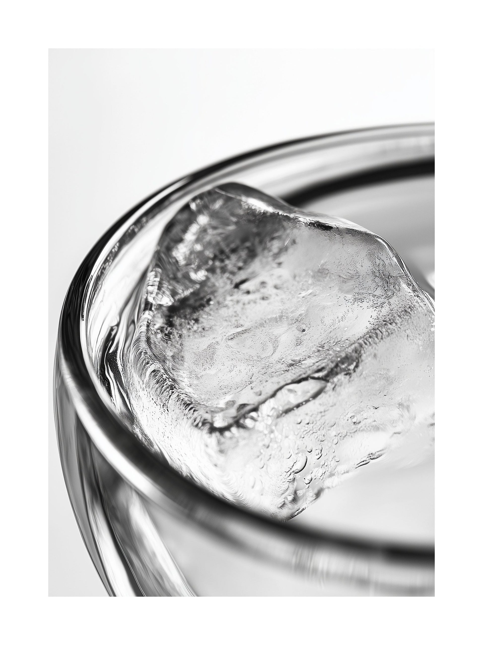 Close-up black and white photo of an ice cube in a clear glass