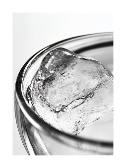 Close-up black and white photo of an ice cube in a clear glass