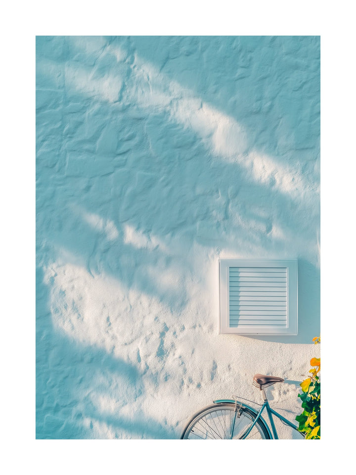 Light blue wall with shadows and a bicycle in a coastal Mediterranean town. Ideal for wall art in your home, office, or studio.