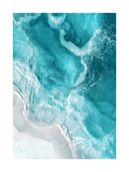 Aerial view of teal and icy blue ocean waves crashing on pale sandy shore. Ideal for wall art in your home, office, or studio.